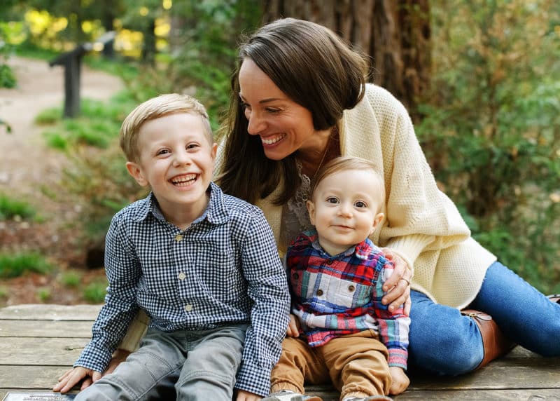 mom with two young boys laughing together during fall family photos