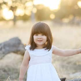 young girl walking along the fields of folsom california during family photo shoot