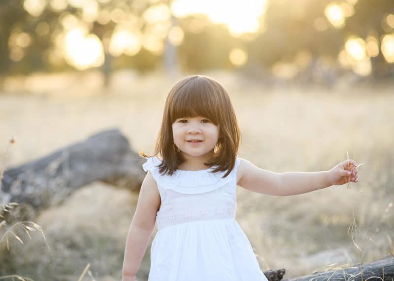 young girl walking along the fields of folsom california during family photo shoot