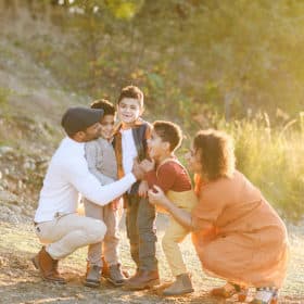family of five looking at one another by the water during golden hour in fall sacramento california