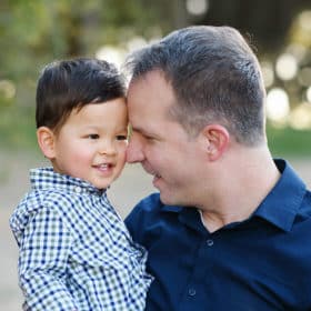 dad and young son touching foreheads and smiling during family photo shoot in sacramento california
