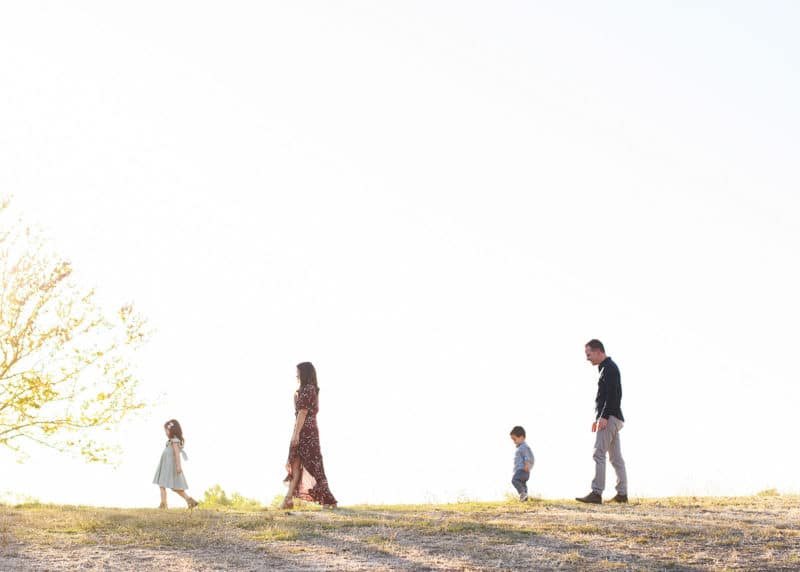family of four silhouette of walking together on a hill during sunset in sacramento california
