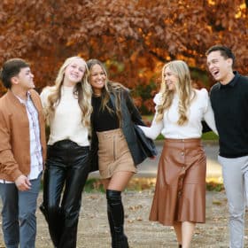 grown siblings walking together holding hands during fall family photos