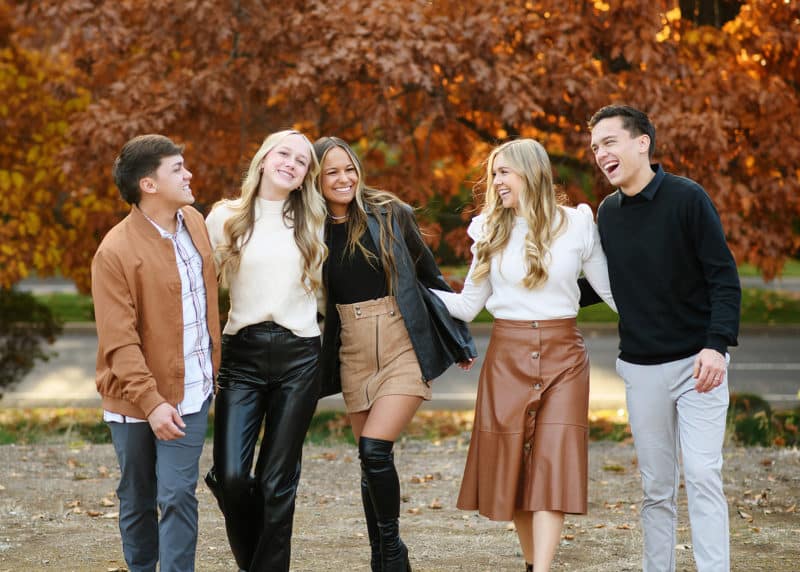 grown siblings walking together holding hands during fall family photos