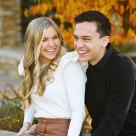 couple looking at one another and laughing during fall family photos in el dorado hills california