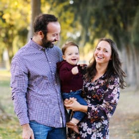 mom and dad holding baby boy during fall family photo shoot