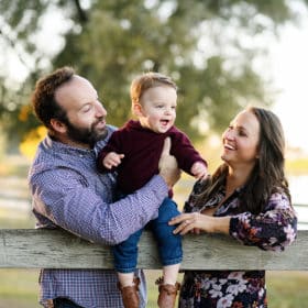 mom and dad looking at young son and laughing during outdoor fall photos