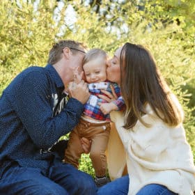 mom and dad kissing baby boy on the cheeks during fall family photos in davis california