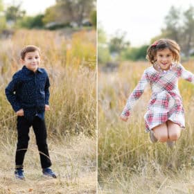 young boy standing in a field during family photos, young girl jumping in a holiday dress