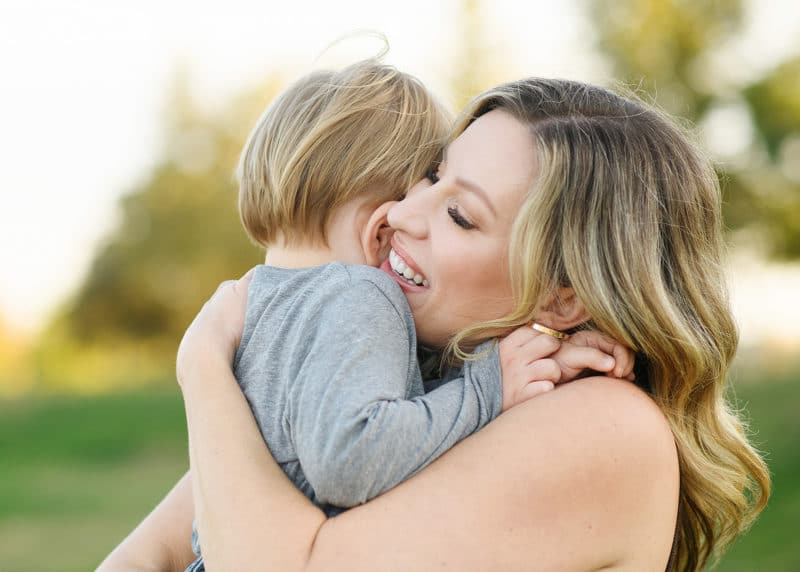 mom hugging young son during family photos in sacramento california