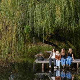 four teenage siblings sitting on the dock at family farm in sacramento california