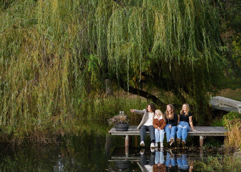 four teenage siblings sitting on the dock at family farm in sacramento california