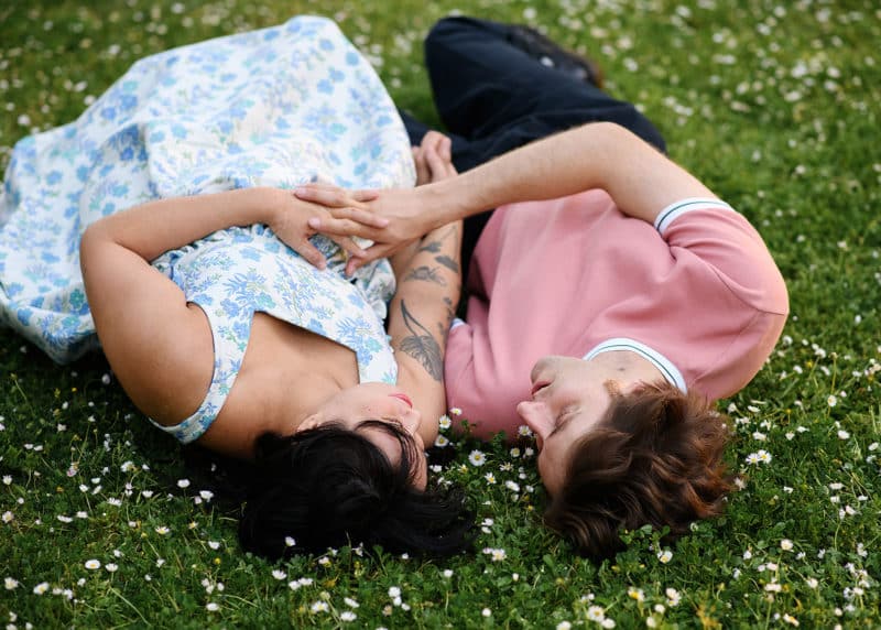 maternity session lying in a field of white daisy flowers