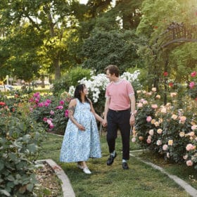 pregnant couple walking through a rose garden during spring in sacramento california