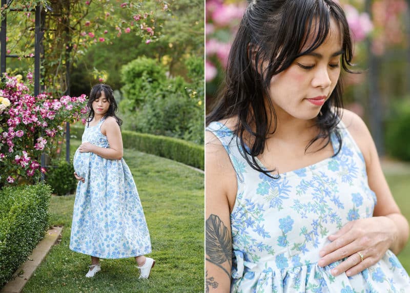 pregnant woman holding her belly in a flower garden in sacramento california