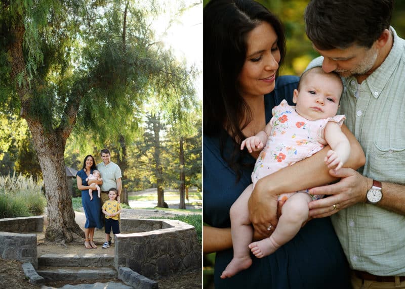 family of four standing under a tree, mom and dad holding baby girl in sacramento california