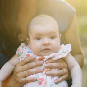 mom holding newborn baby girl during spring family photos in sacramento california