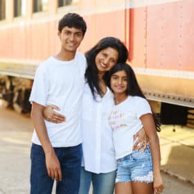 mom with son and daughter hugging in front of a train in folsom california