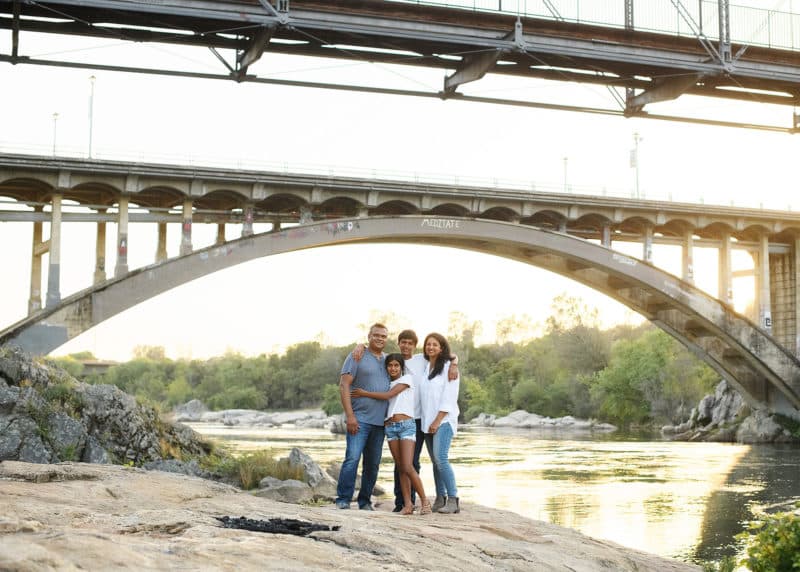 taking family photos in the natural light under a bridge in folsom california