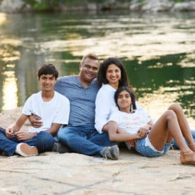 family of four sitting together by a river in folsom california