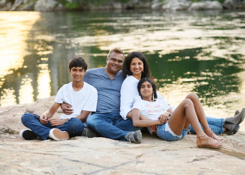 family of four sitting together by a river in folsom california