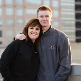 senior in high school taking portraits with his mom on the roof of a building in downtown sacramento california