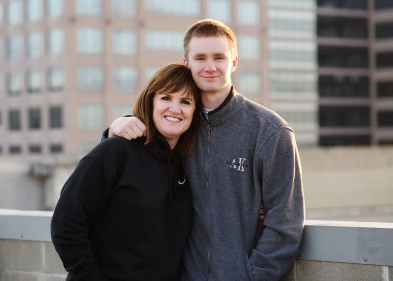 senior in high school taking portraits with his mom on the roof of a building in downtown sacramento california
