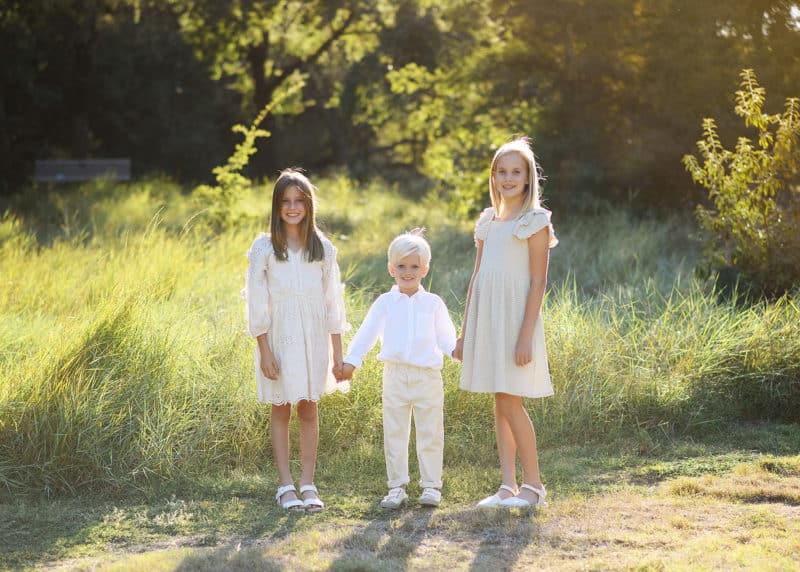 three young siblings holding hands during family photos in Davis, California
