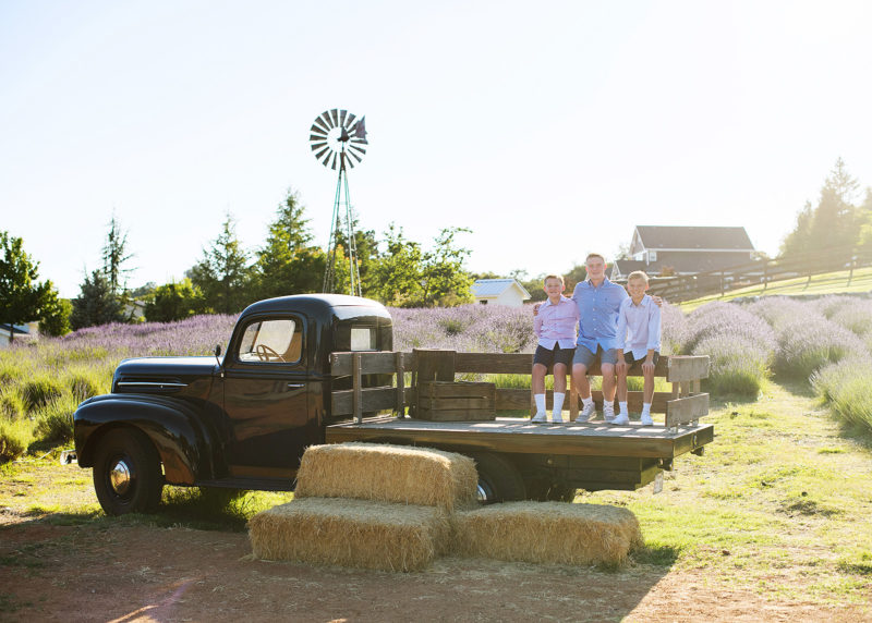 three young brothers sitting on an old truck in the middle of a lavender field in newcastle california