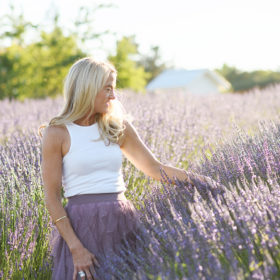 mom walking through the lavender fields in newcastle california looking at the flowers during summer family photos