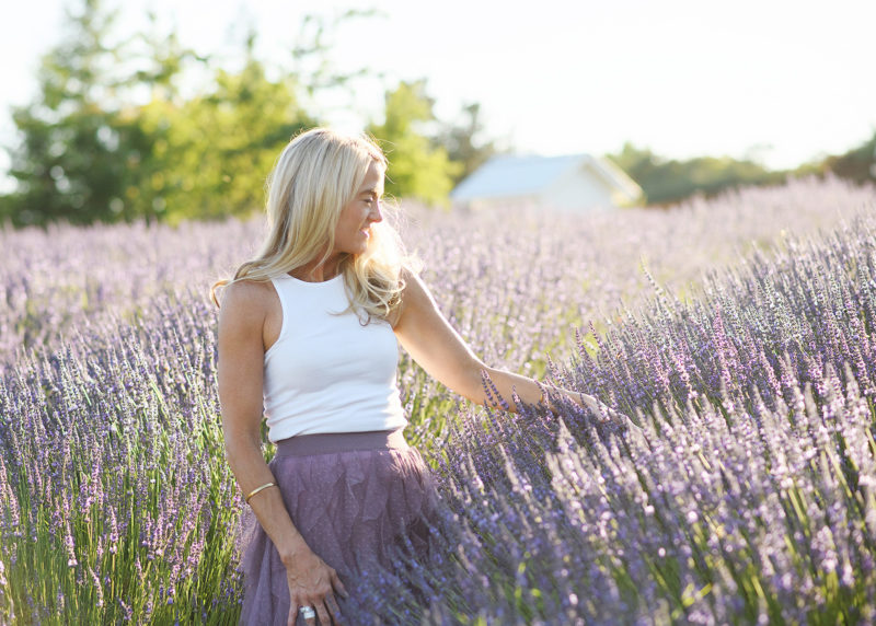 mom walking through the lavender fields in newcastle california looking at the flowers during summer family photos