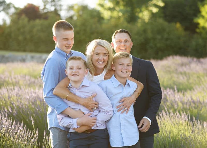 taking family photos in a lavender field during summer and laughing together