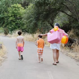 family of three walking away with beach bags after a day at folsom lake