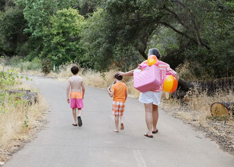 family of three walking away with beach bags after a day at folsom lake