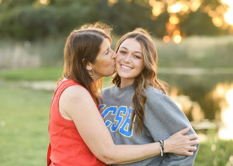 mom kissing daughter on the cheek during senior portraits in sacramento california