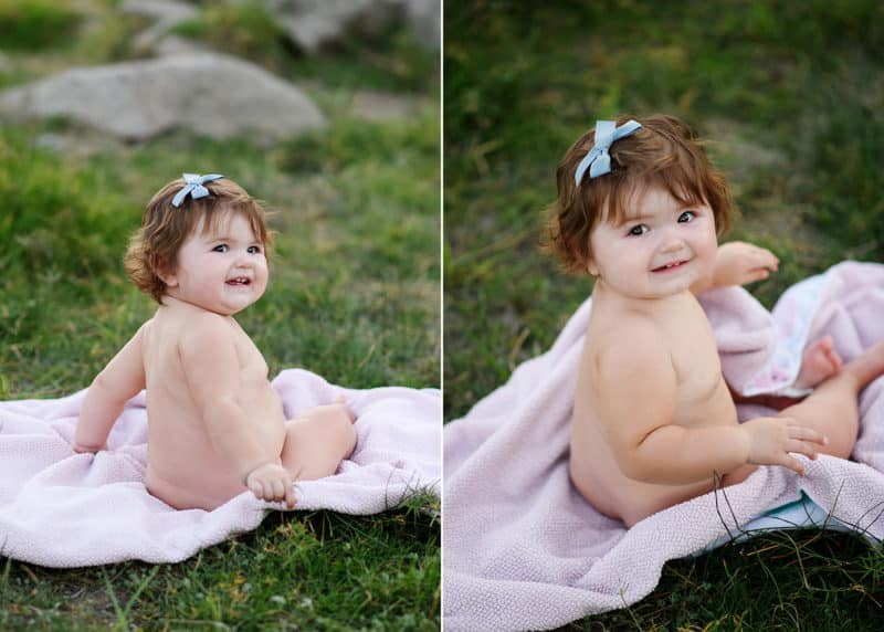 baby girl sitting on a blanket in the grass looking at the photographer during family photos in granite bay california