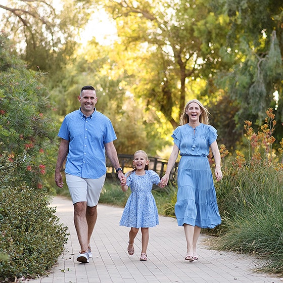 family of three walking toward the photographer in a park in davis california