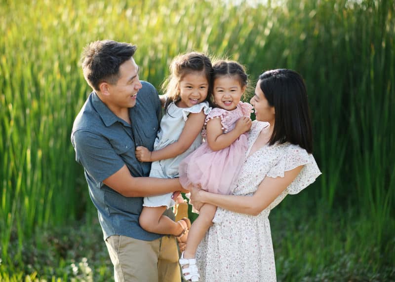 family of four giggling and smiling during family photos in sacramento california