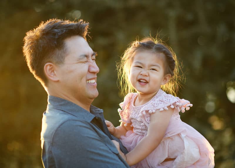 dad and young daughter laughing during family photography session in sacramento california