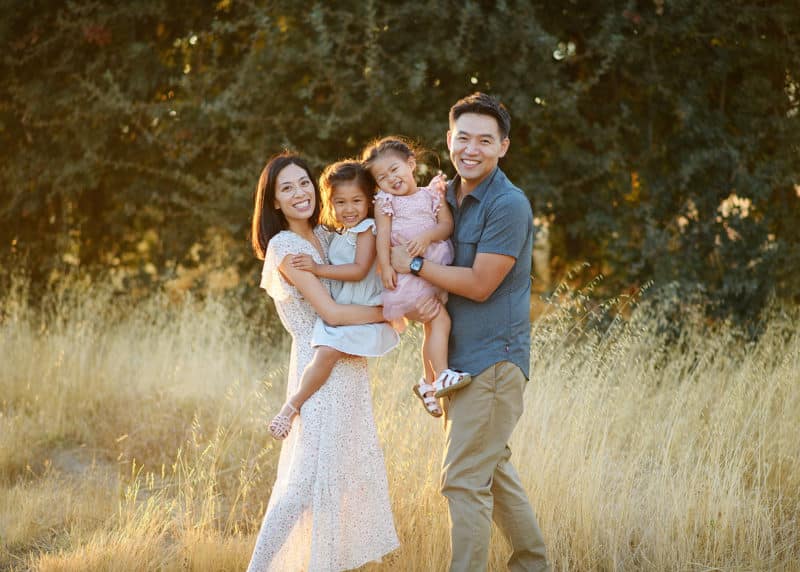 family of four taking photos in a field during photography session in sacramento california