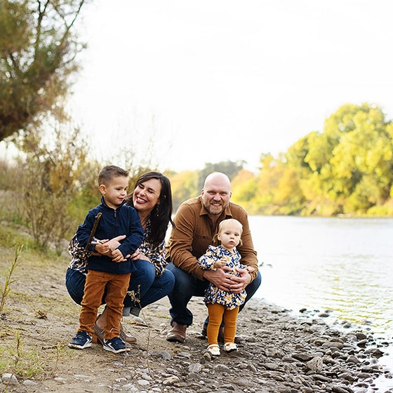 young family taking fall pictures by the river in sacramento california