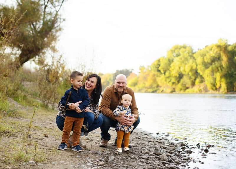 young family taking fall pictures by the river in sacramento california