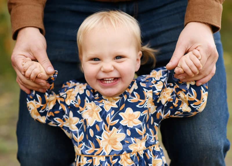 young girl smiling at a camera during fall family photos with sacramento photographer jill carmel