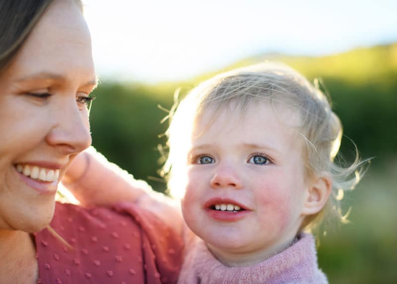 mom looking at young daughter in the golden sunlight with a tahoe family photographer