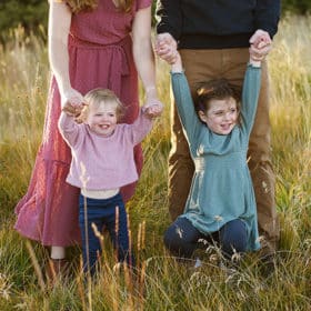 two young girls holding hands with mom and dad during family photography session in lake tahoe california