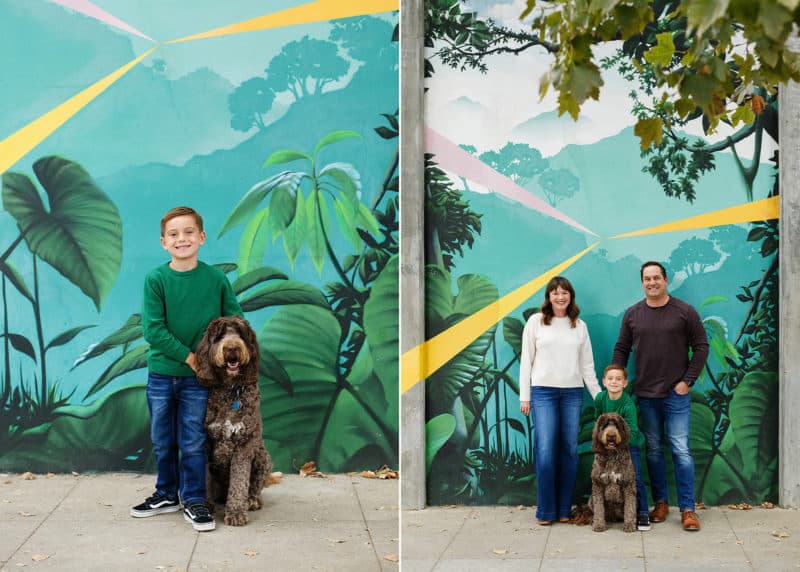 young boy standing in front of a mural in downtown sacramento california with his dog, family of three with dog in front of mural