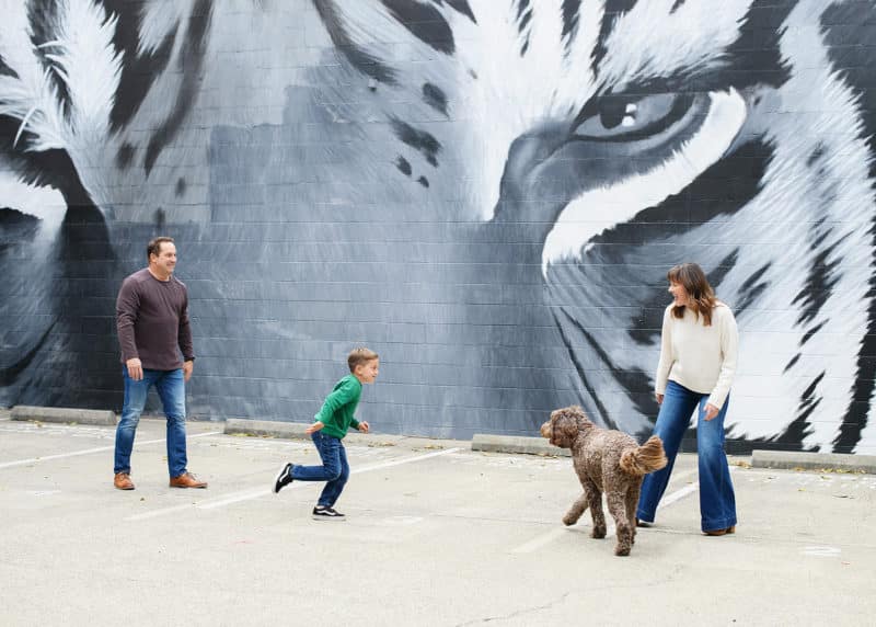 sacramento photographer snapping pictures as young boy runs around with his dog while mom and dad watch