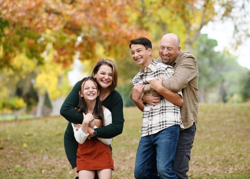 mom and dad tickling young children and laughing during photo session in sacramento california