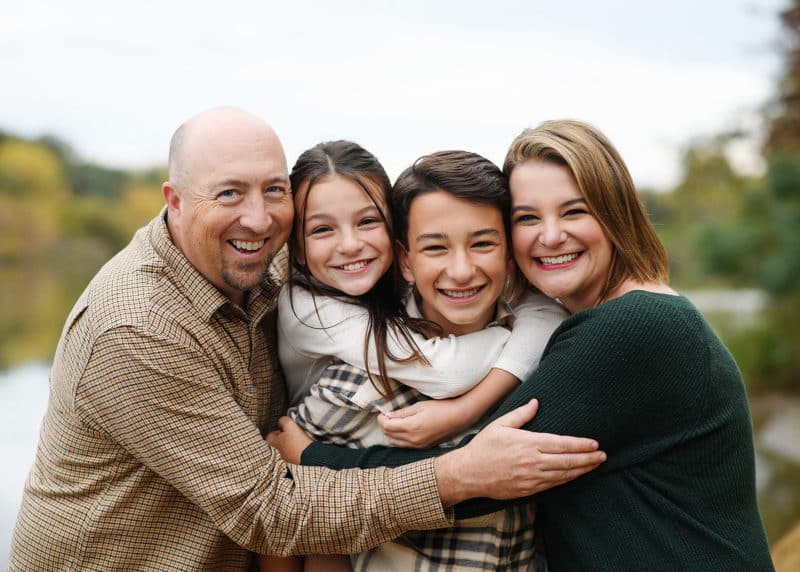 Sacramento photographer taking pictures of family during fall with the river in the background