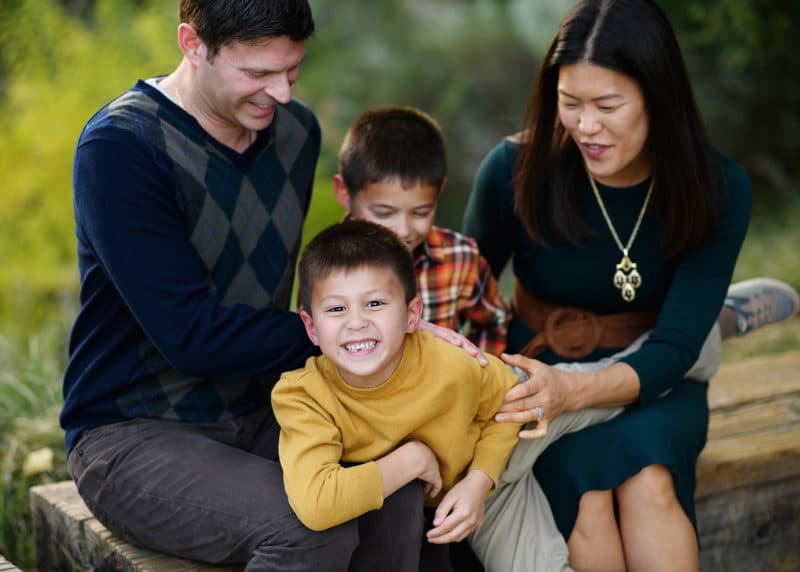 family of four laughing together during fall pictures in davis california with professional photographer 